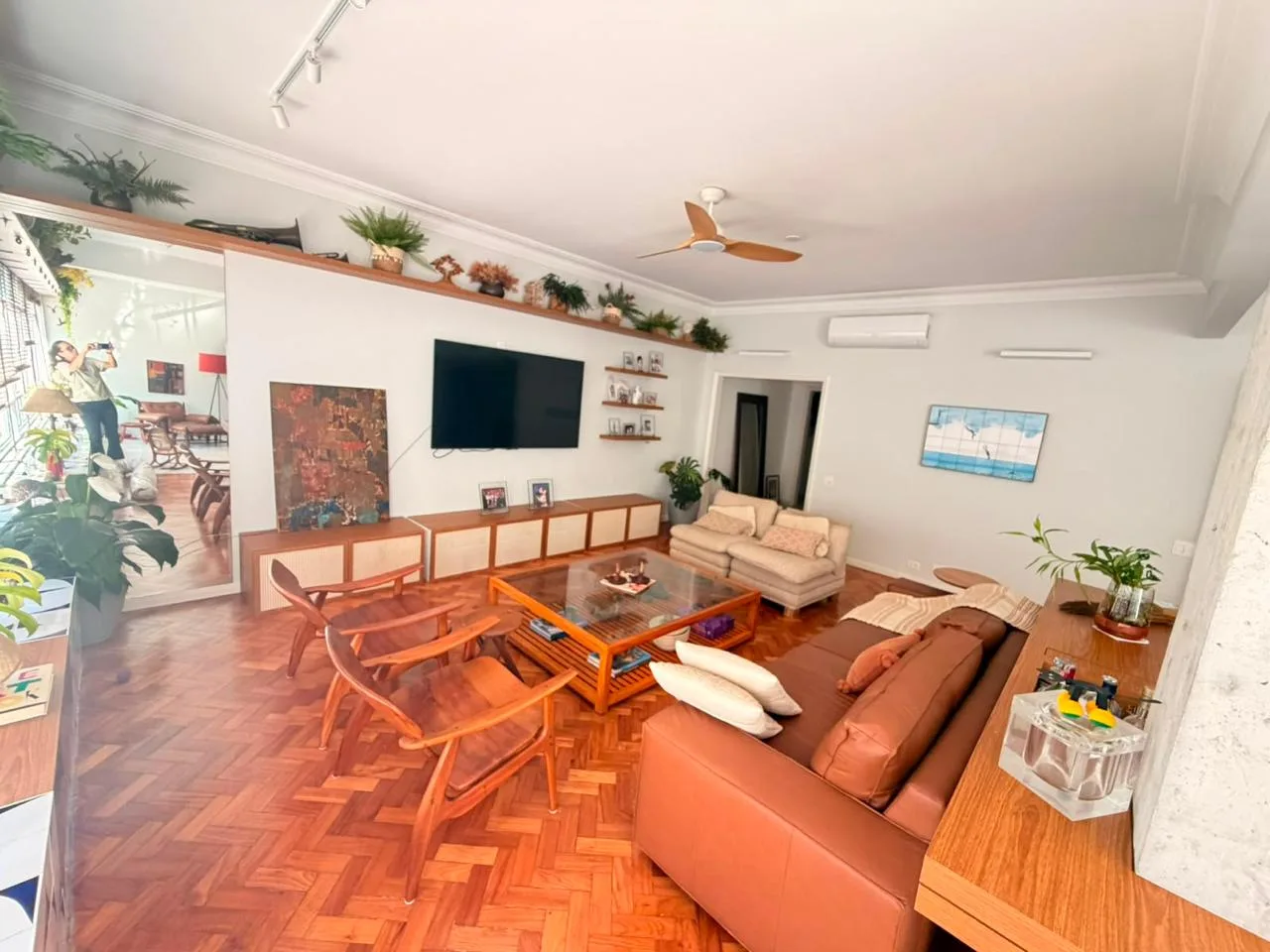 Sala de estar com piso de taco e estante com plantas