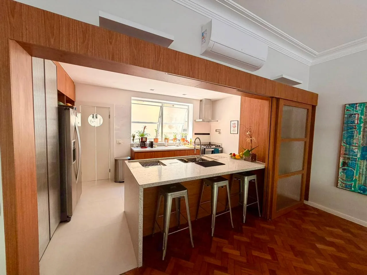 Segundo ambiente do living, com poltronas e luminária