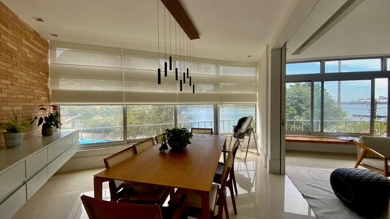 Sala de jantar com mesa de madeira e vista para a Lagoa