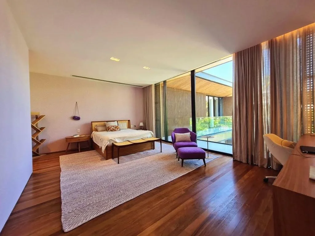 Quarto com cama de casal e poltrona lilás
