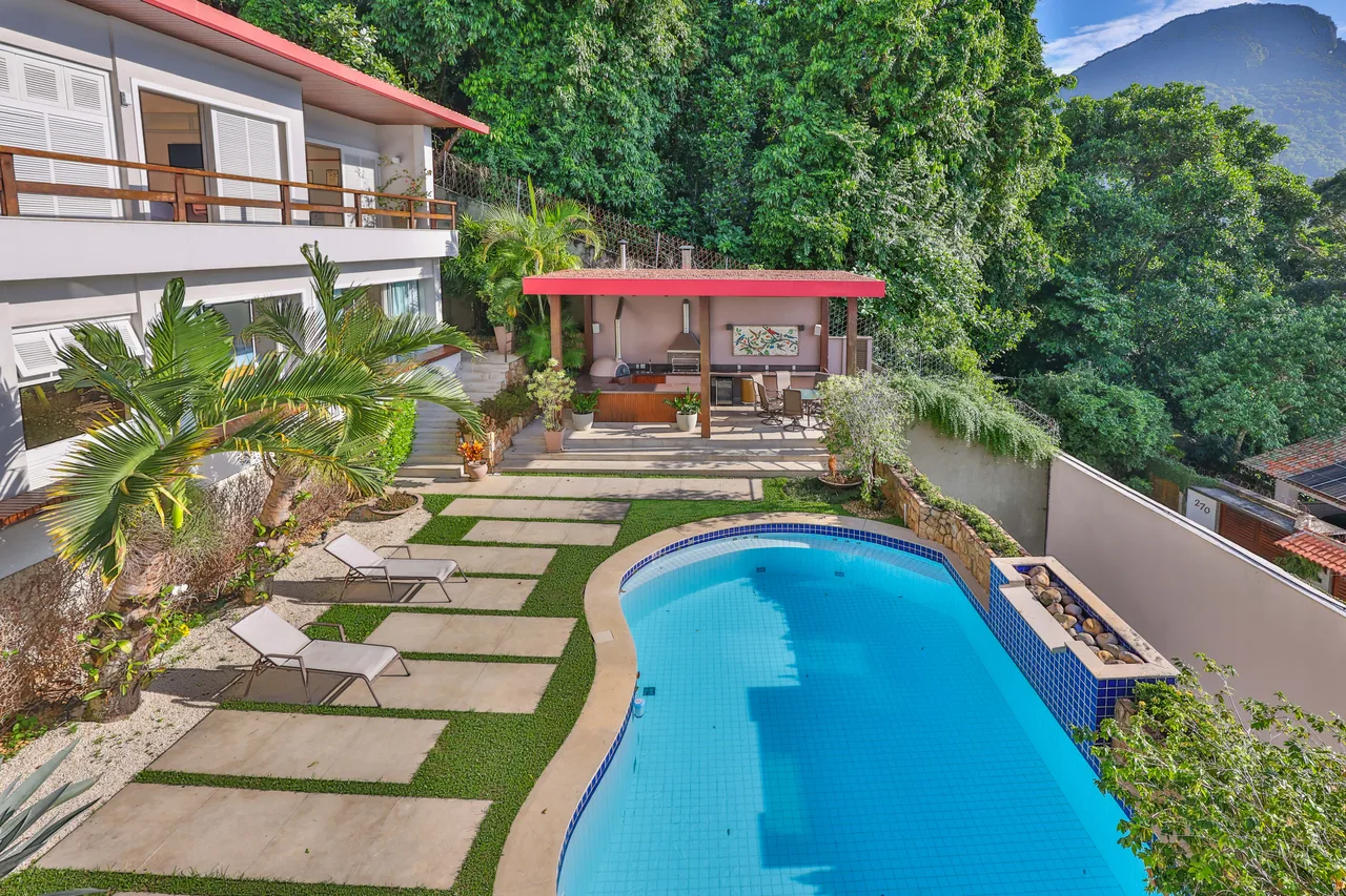 Piscina com deck de madeira e jardim