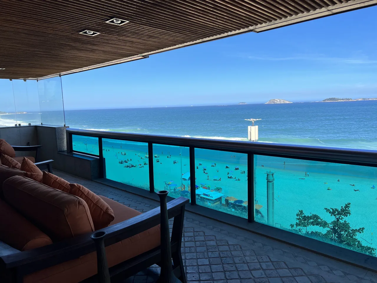 Terraço com mesa de jantar externa e vista para o mar