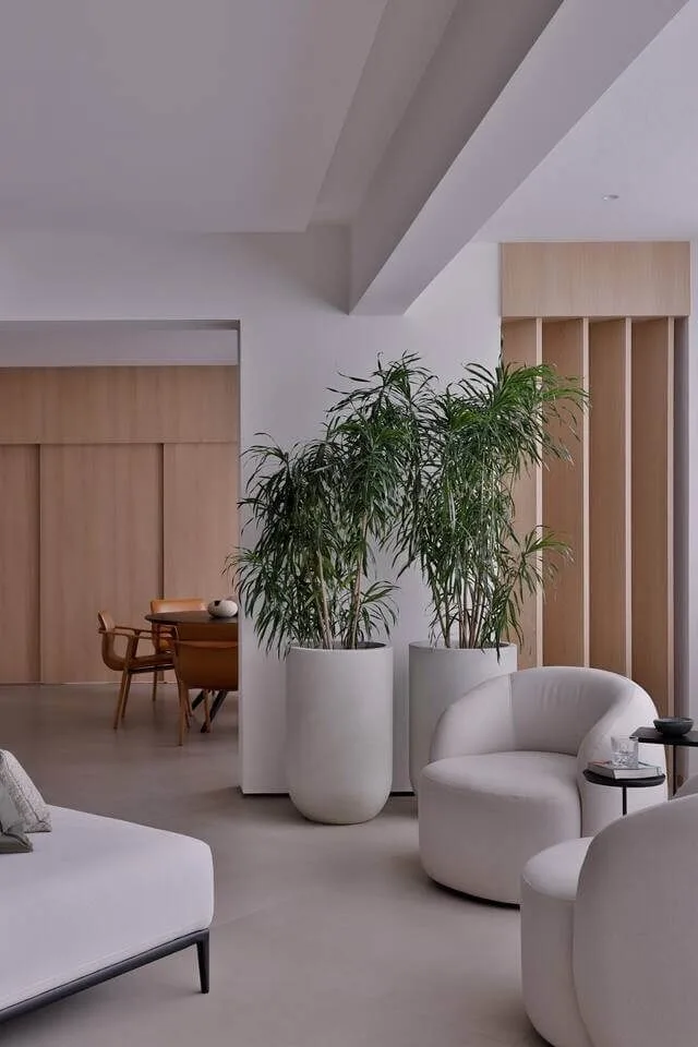 Ambiente integrado com poltronas estofadas e paisagismo interno