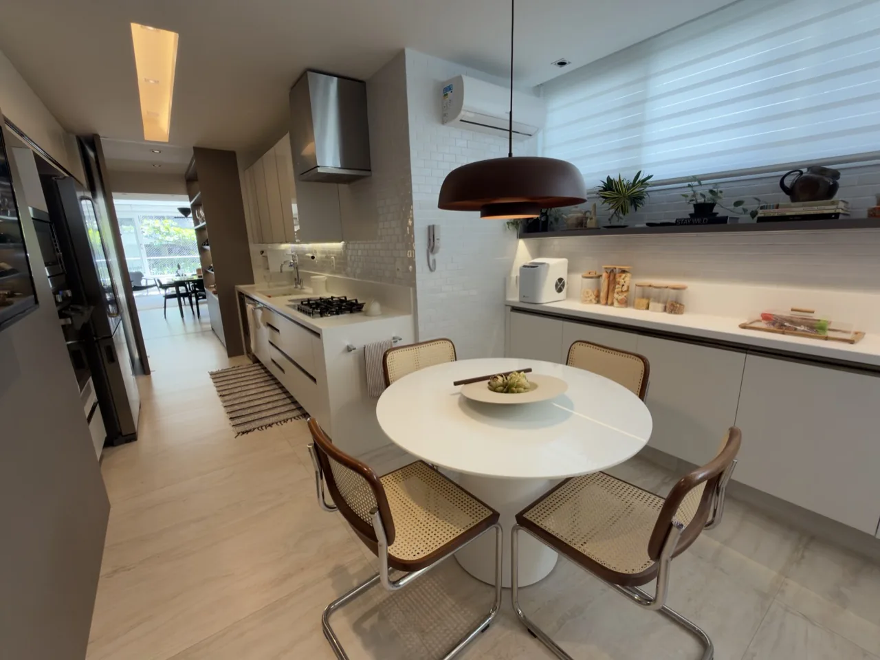 Cozinha planejada com copa e mesa redonda