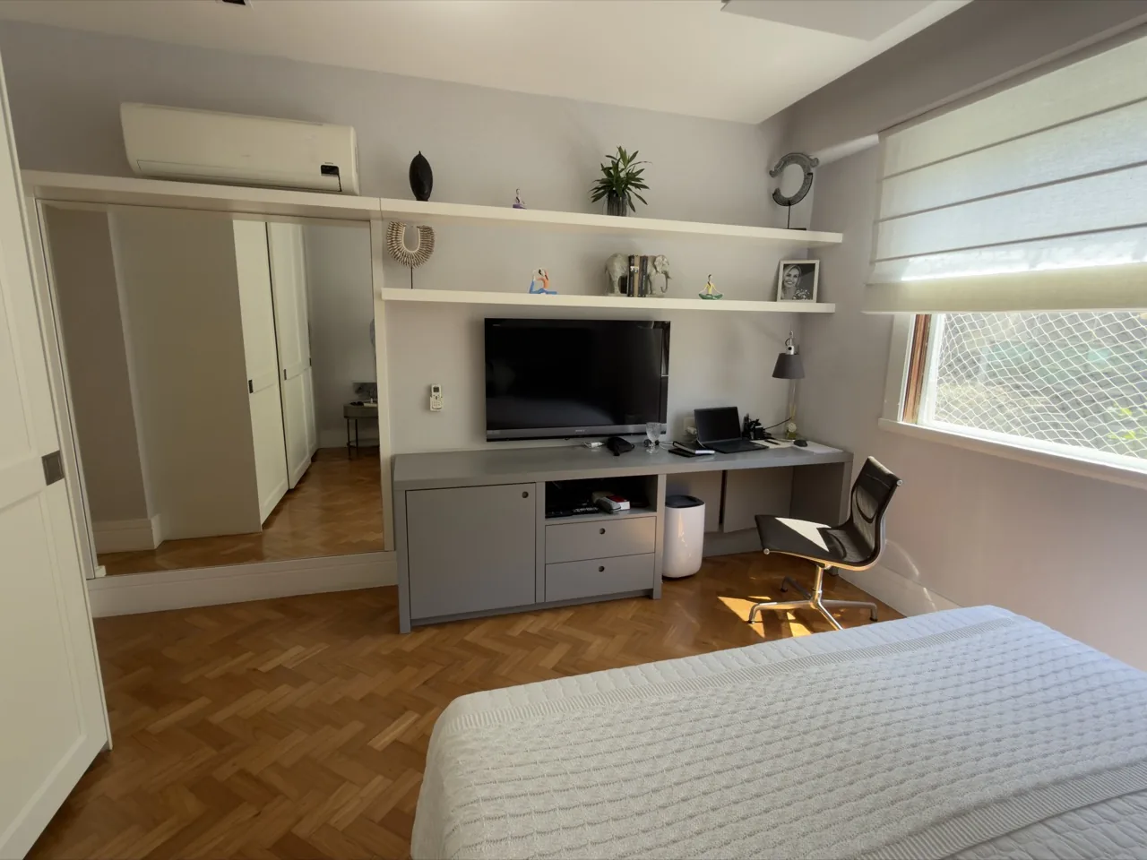 Quarto com bancada de home office e armários espelhados