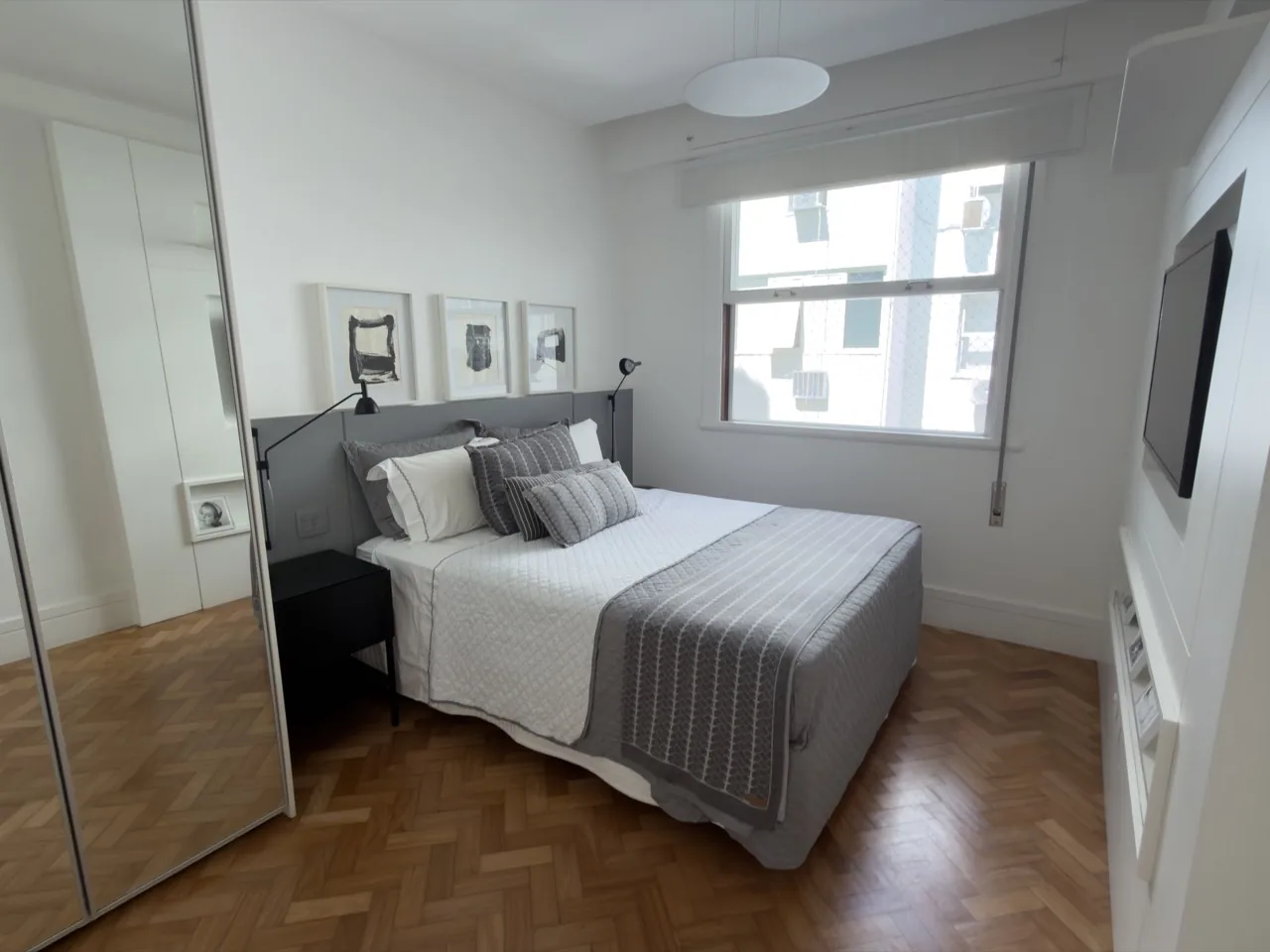 Quarto com painel de TV e armários