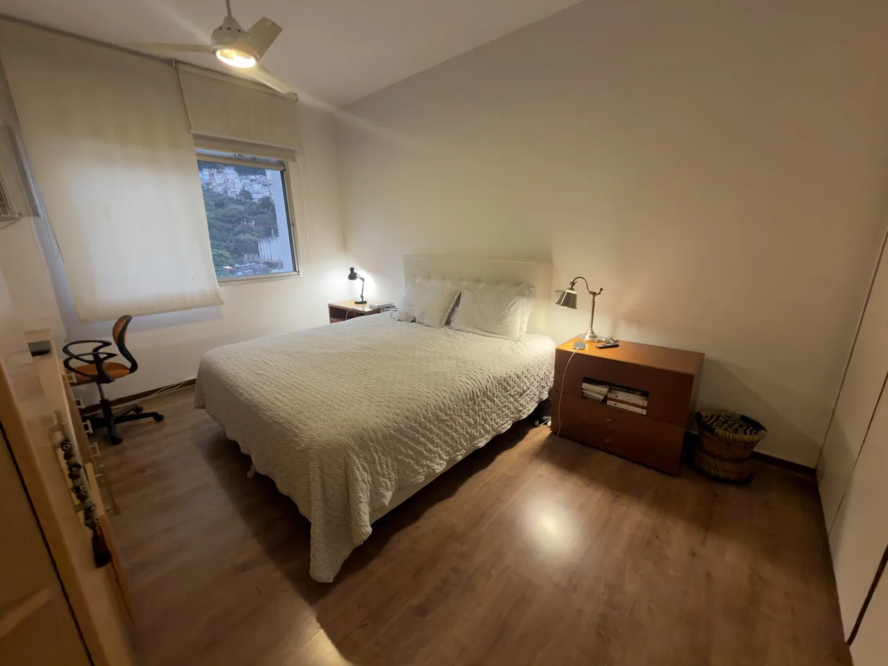 Quarto com cabeceira estofada e criado-mudo