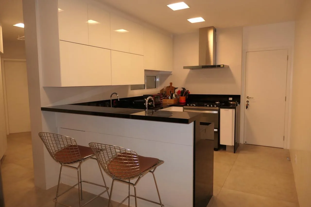 Cozinha com ilha, cooktop e banquetas