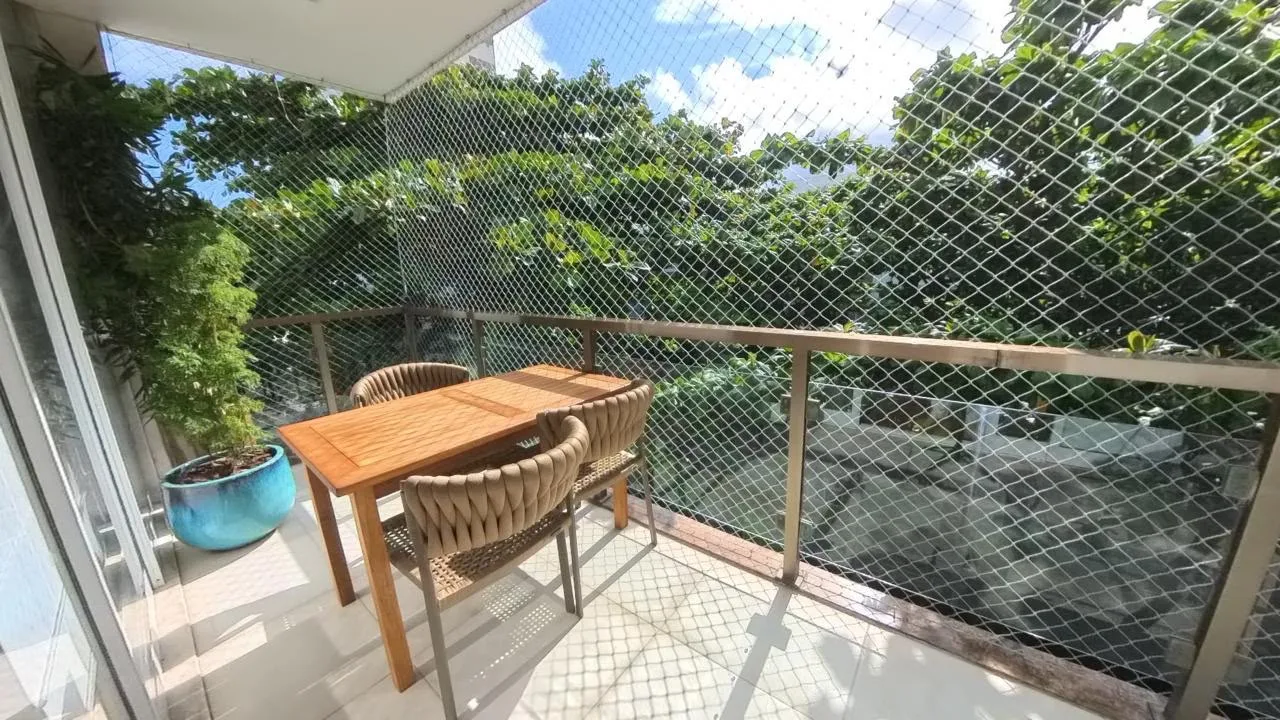 Varandão com mesa e vista arborizada