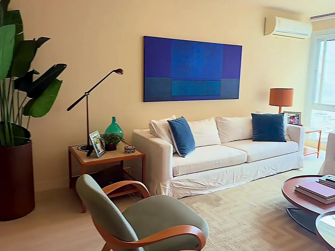 Sala de estar com sofá, poltronas e quadro azul