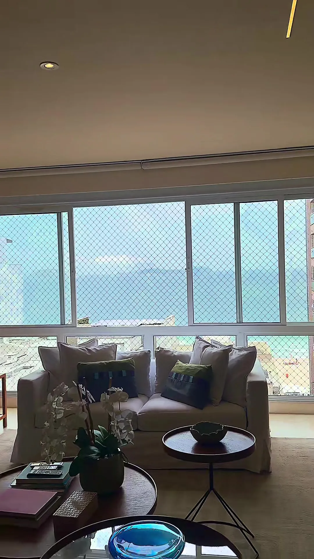 Sala de estar de frente para as janelas com vista para o mar