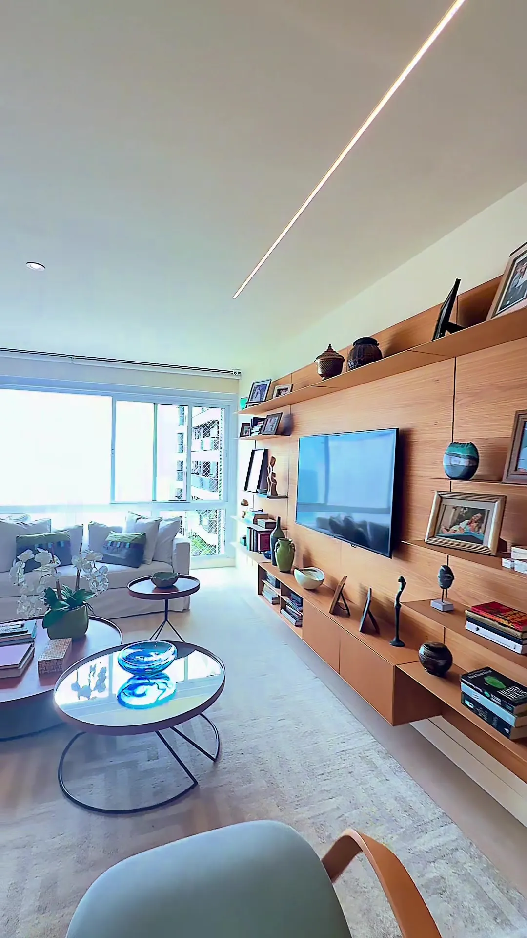 Sala com painel de madeira, TV e sofá