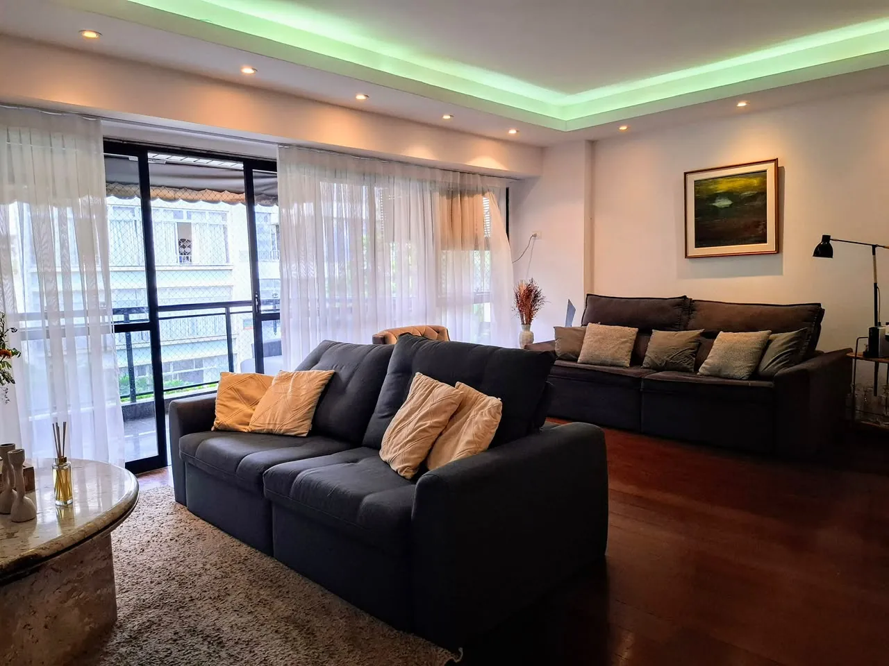 Sala de estar com sofá e janelas para a varanda