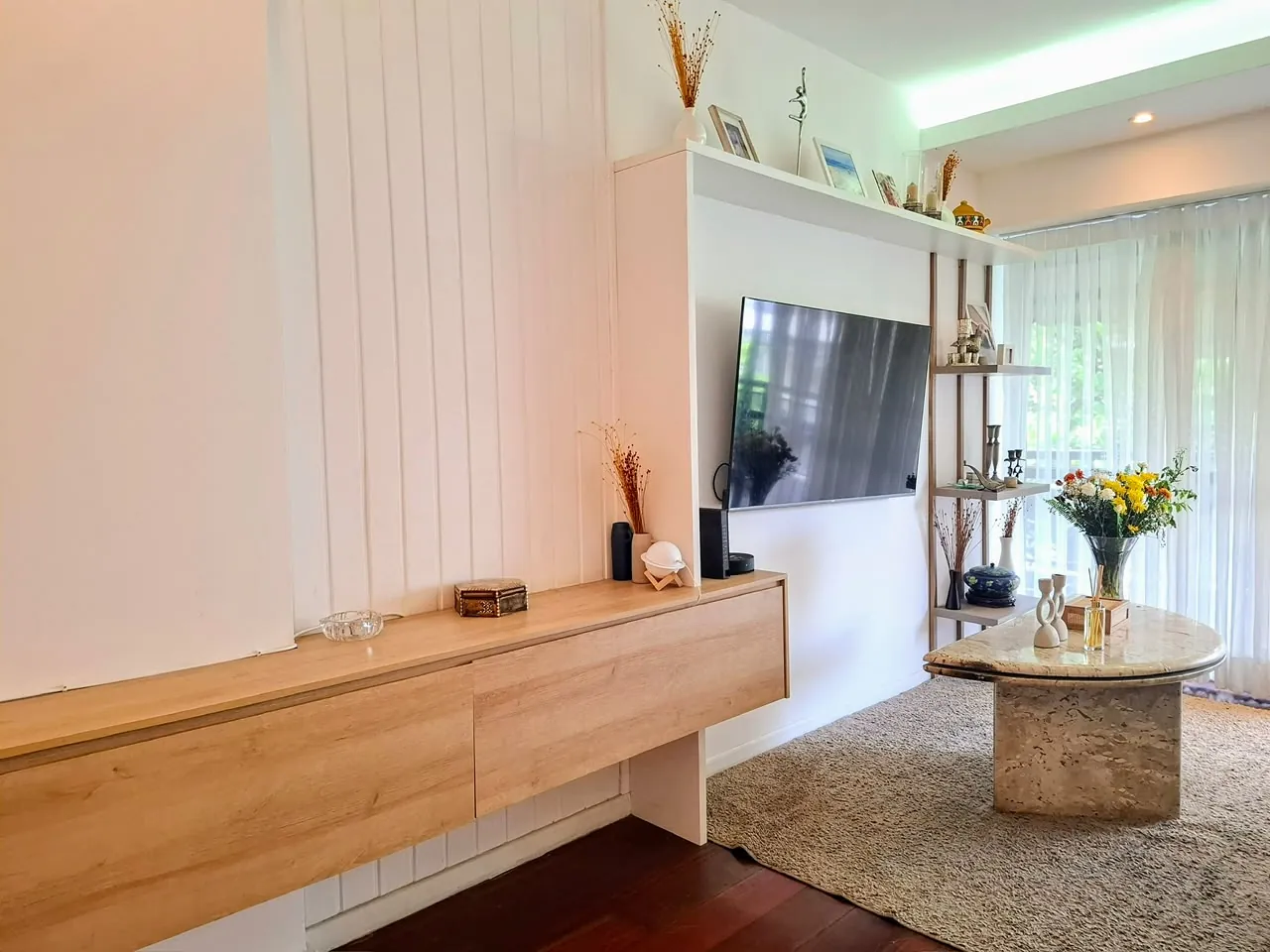 Sala com painel de madeira e vista para a varanda