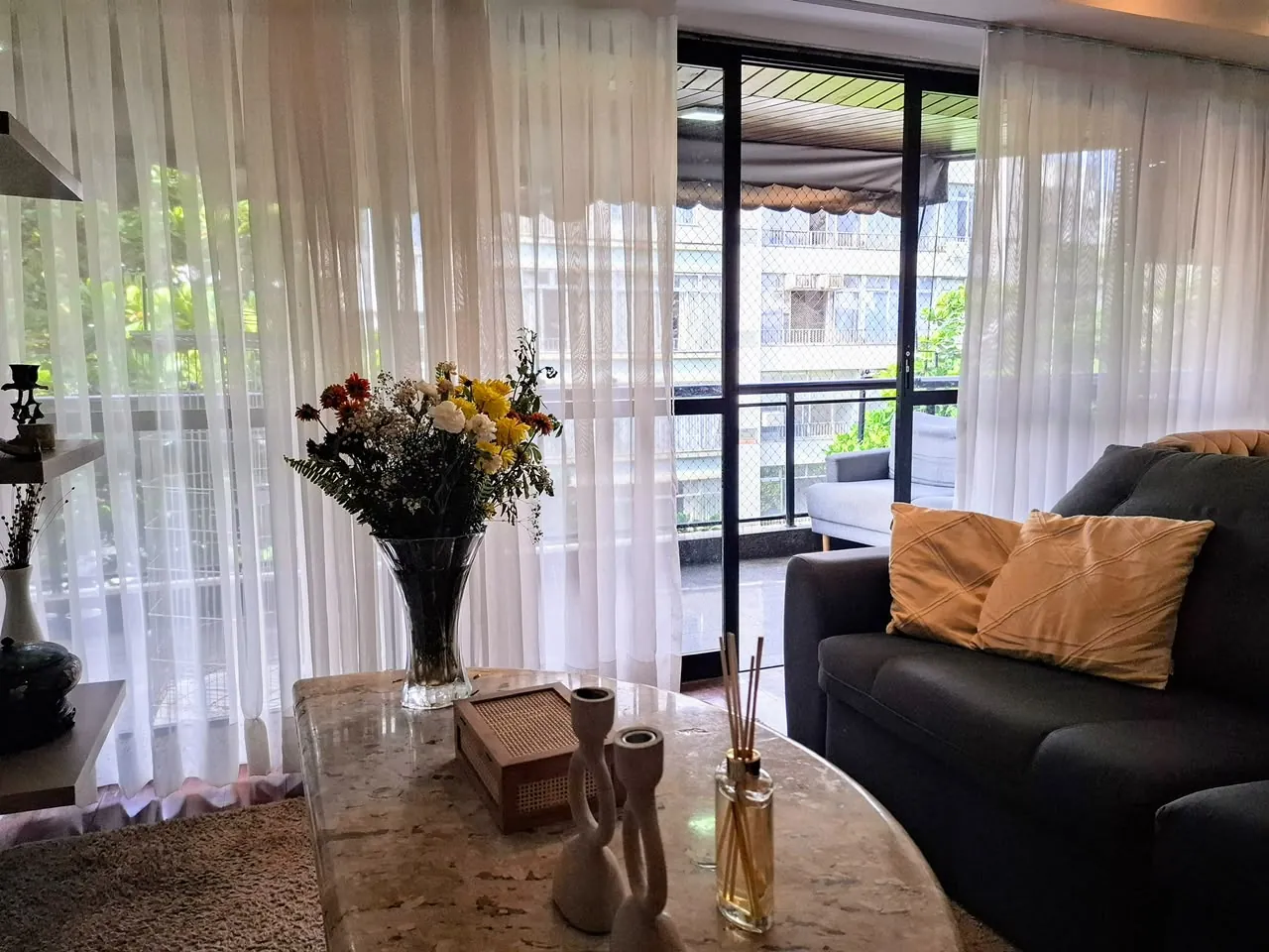 Sala com cortinas leves e vista para o verde