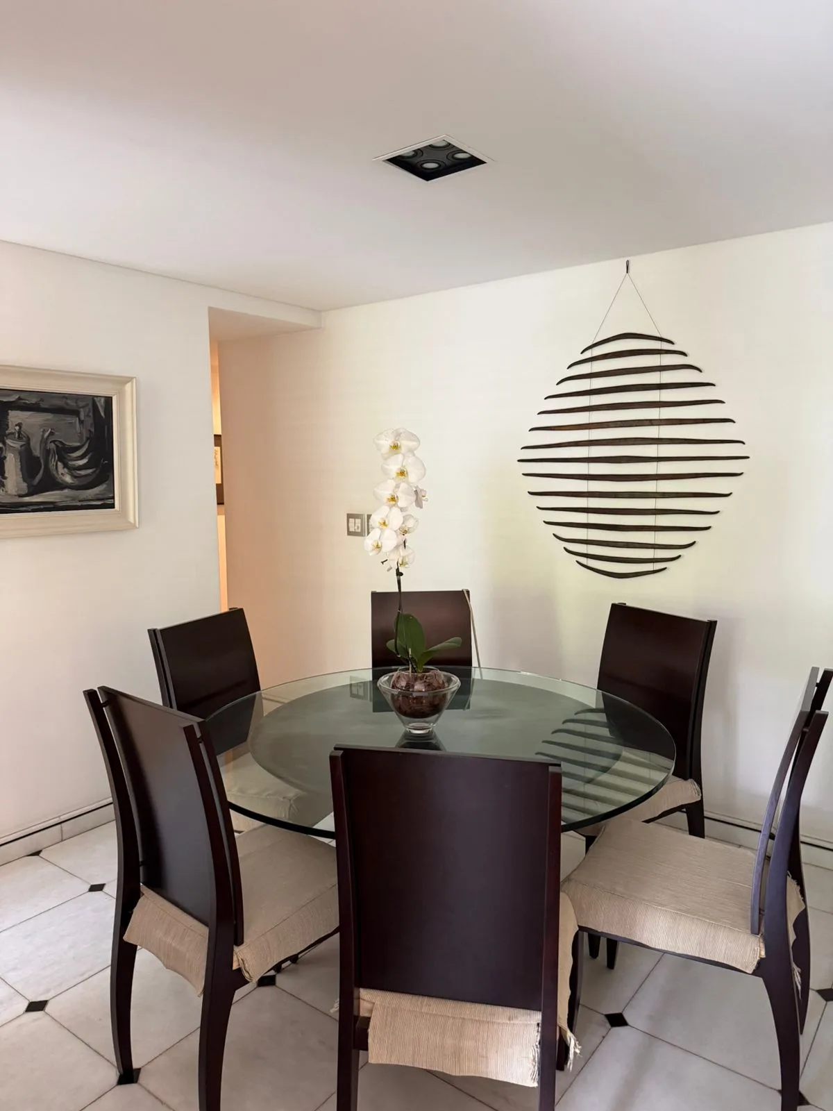 Sala de jantar com mesa redonda de vidro