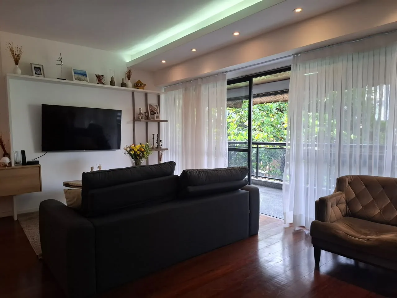 Sala de estar com sofá, poltrona e iluminação em led