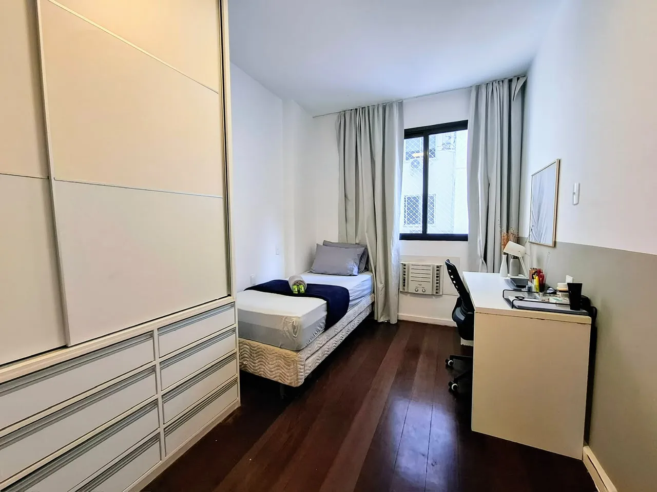 Quarto com cama de solteiro e escrivaninha