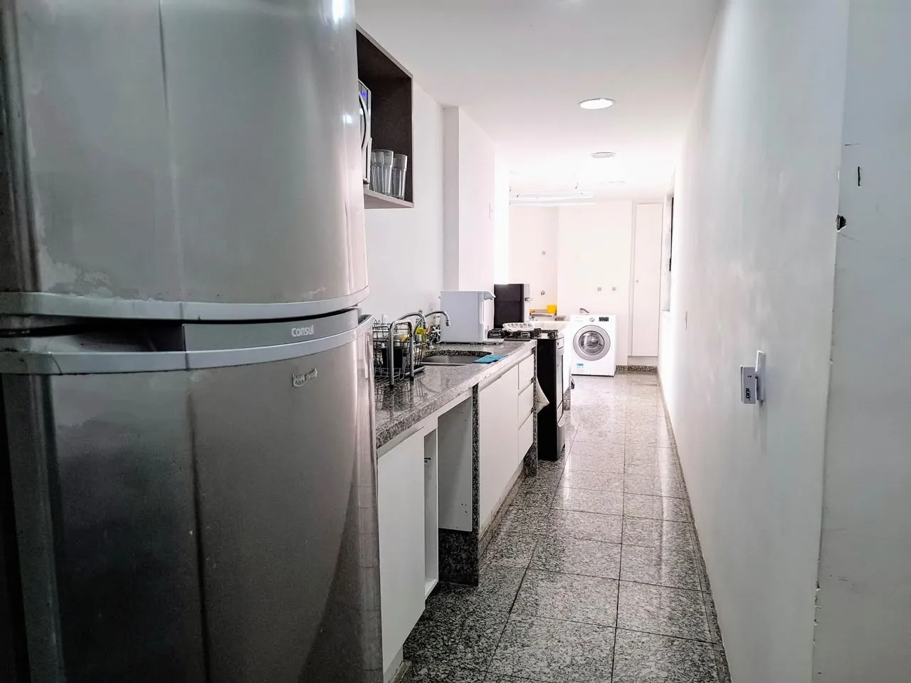 Cozinha com bancada e área de serviço