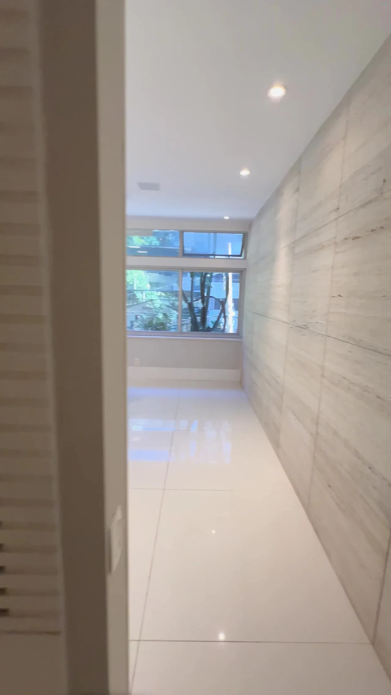 Corredor com parede em porcelanato amadeirado