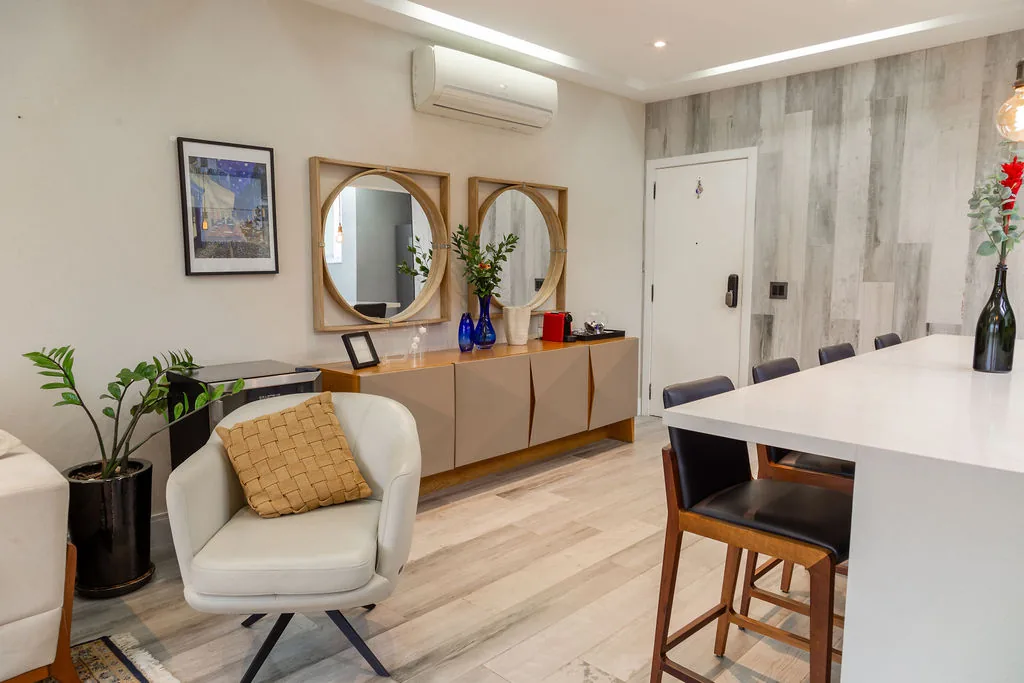 Sala com aparador, espelhos e poltrona