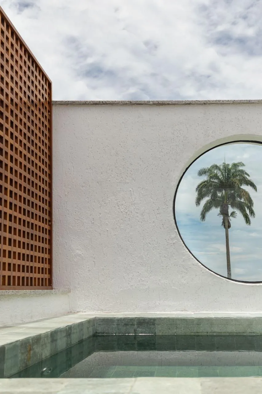 Área da piscina no terraço com deck de madeira e vista para o verde