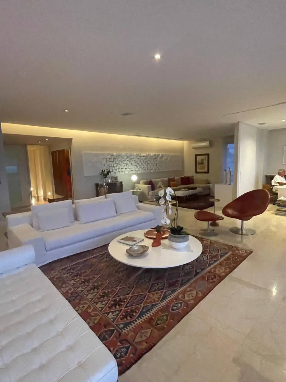 Sala de estar com sofá branco e tapete