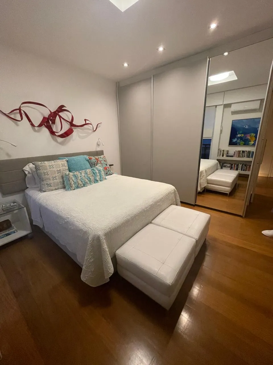 Suíte com cama de casal e piso de madeira