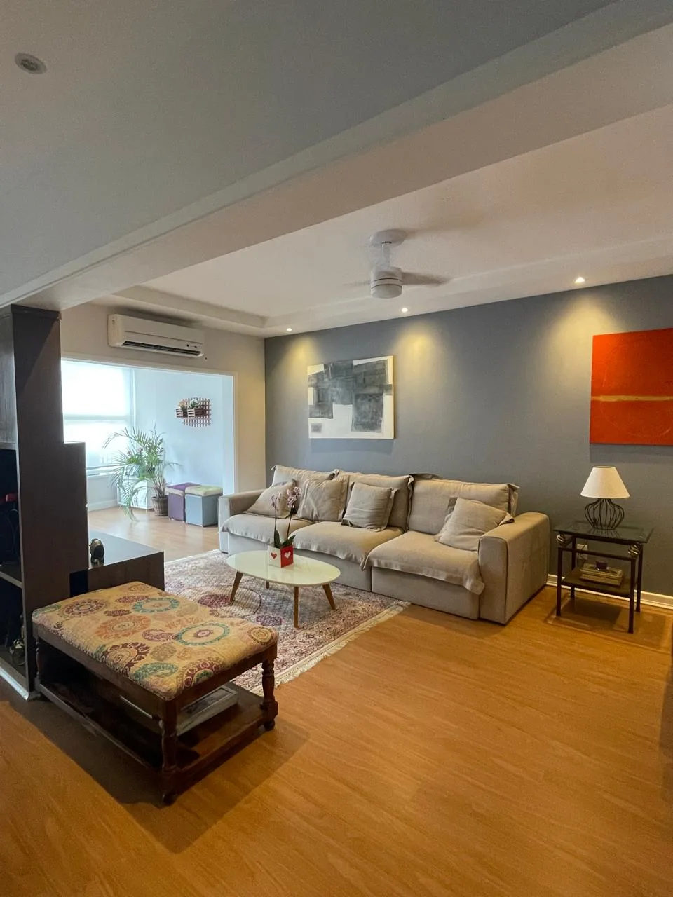 Living amplo com sofás e piso de madeira