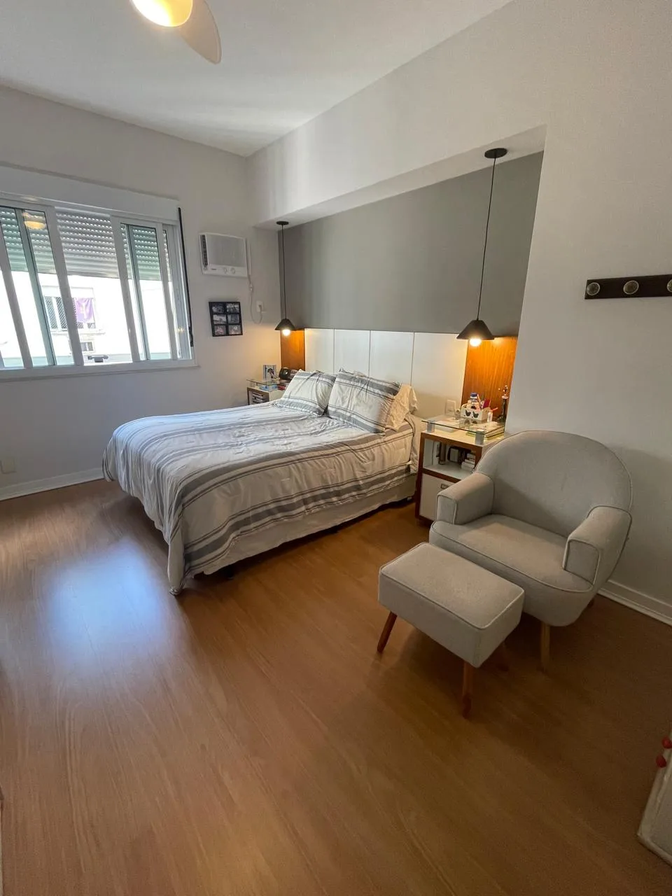 Suíte com poltrona e piso de madeira