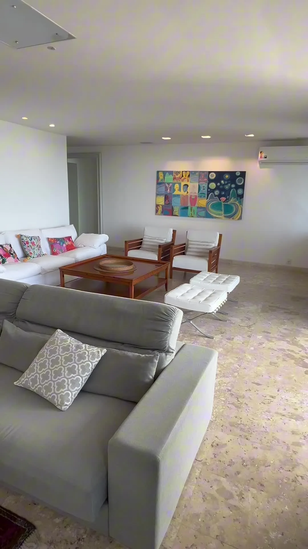 Sala de estar com obra de arte colorida e poltronas de couro